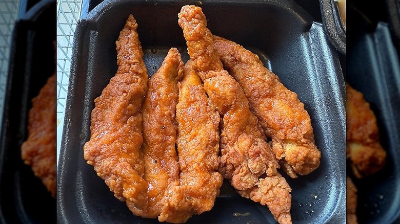 Five Zaxby's chicken tenders sit in a to-go box