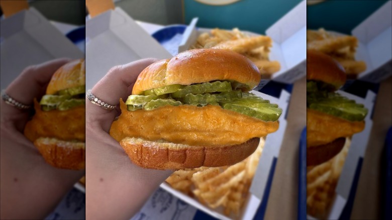 A close up of the long john silver's fish sandwich with extra pickles