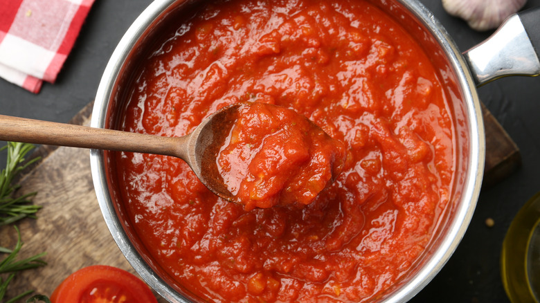Marinara sauce cooking in pot with spoon