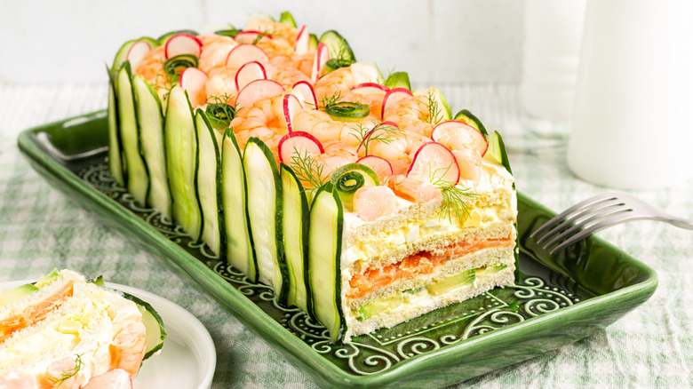 Frosted sandwich loaf garnished with cucumbers and radishes