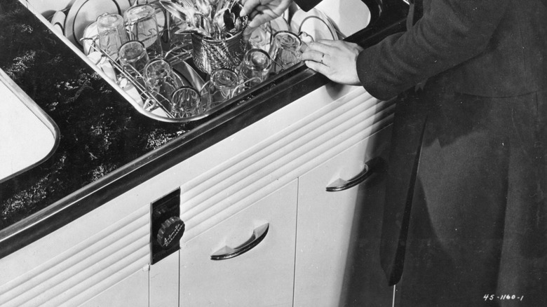 Person loading dishes into dishwasher from the top