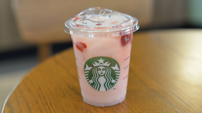 Starbucks Pink Drink sits on a wooden table