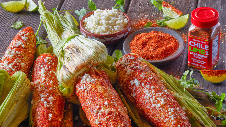 Jar of Trader Joe's Chili Lime Seasoning Blend with freshly seasoned cobs of corn