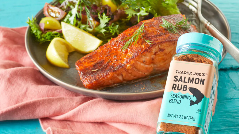 Jar of Trader Joe's Salmon Rub with plate of seasoned salmon and and leafy greens