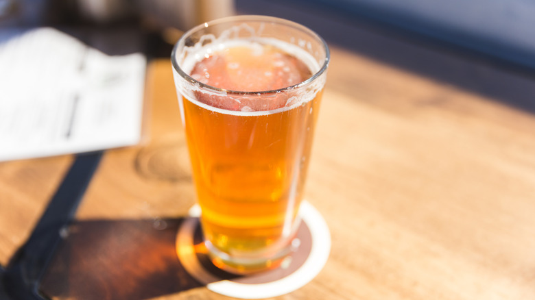 A glass of beer on a wooden counter