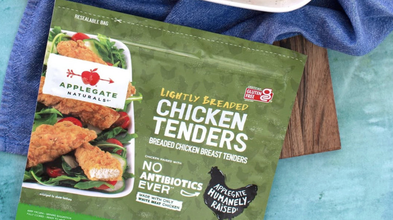 Bag of Applegate Lightly Breaded Chicken Tenders laying atop a board and towel.