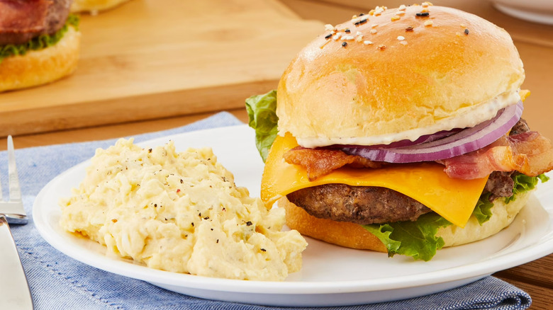 Walmart Freshness Guaranteed Deviled Egg Potato Salad next to a bacon cheeseburger.