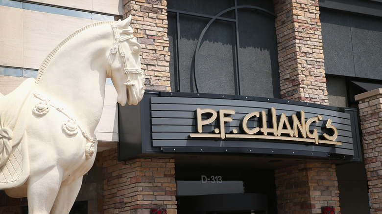 The exterior of a P.F. Chang's with a large stone horse sculpture