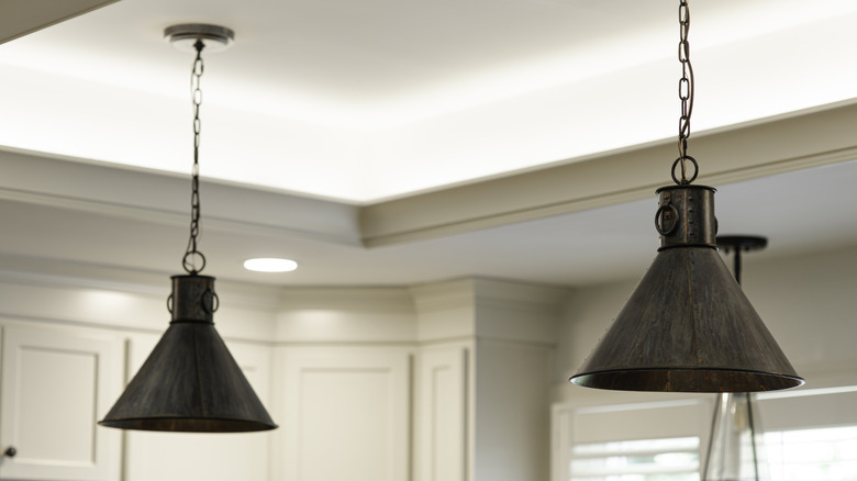 Two hanging pendant light fixtures in a light-colored kitchen