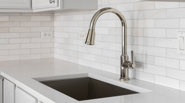 White ceramic tile backsplash behind a kitchen sink