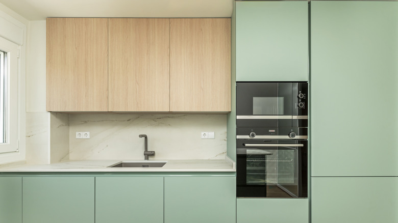 Front image of a kitchen with pastel green cupboards