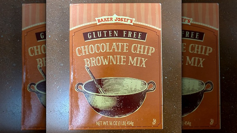 A box of Trader Joe's Gluten-Free Chocolate Chip Brownie Mix lies on a brown counter