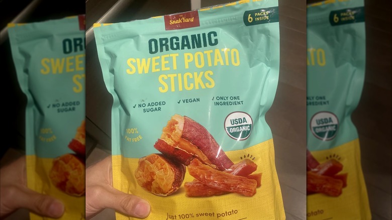 Hand holding SnakYard Organic Sweet Potato Sticks