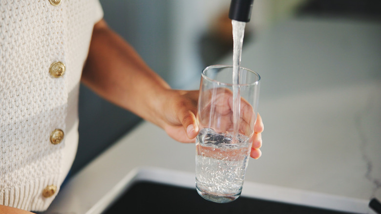 water from kitchen sink filling a glass