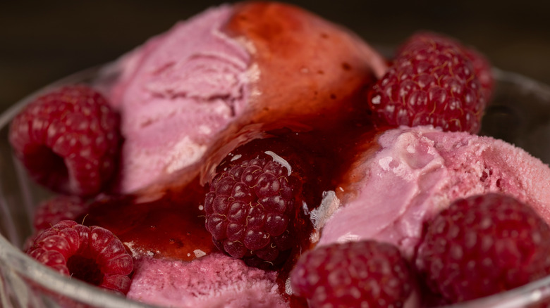 close-up of raspberry ice cream with syrup or honey and raspberries
