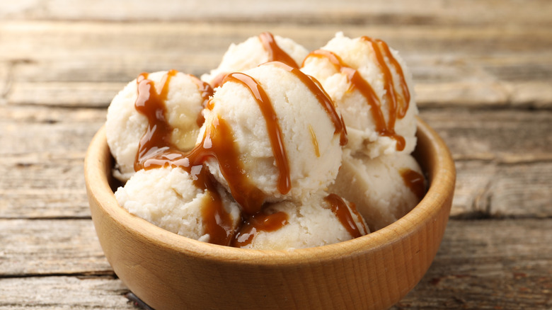 vanilla ice cream in a wooden bowl with caramel drizzle