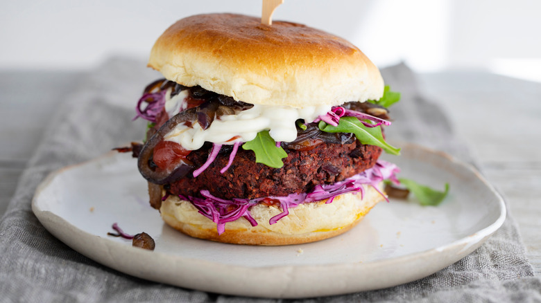 A black bean and beetroot burger with cabbage.