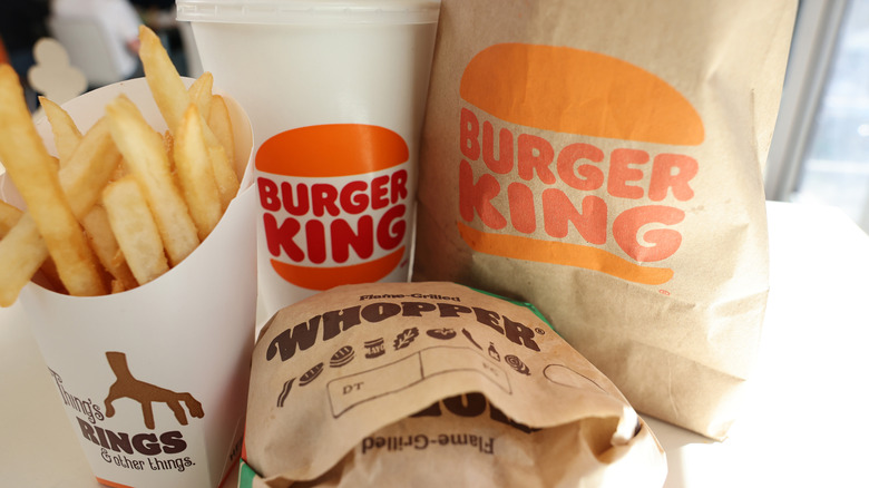 Burger King fries, drink, whopper, and a bag in background
