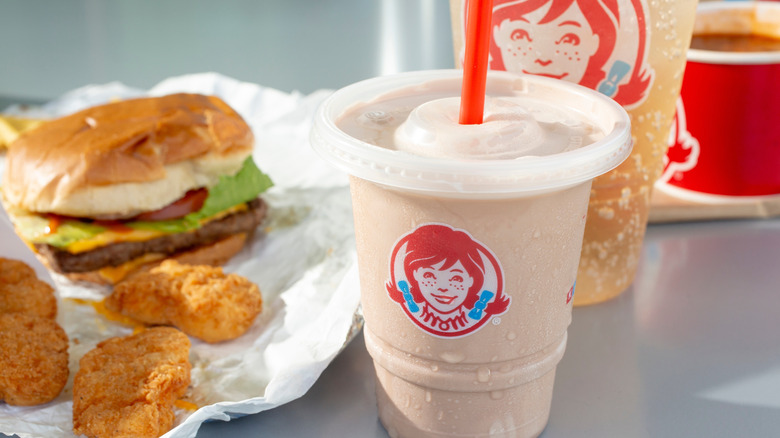 Wendy's burger, chicken nuggets, Frosty, and drink in background