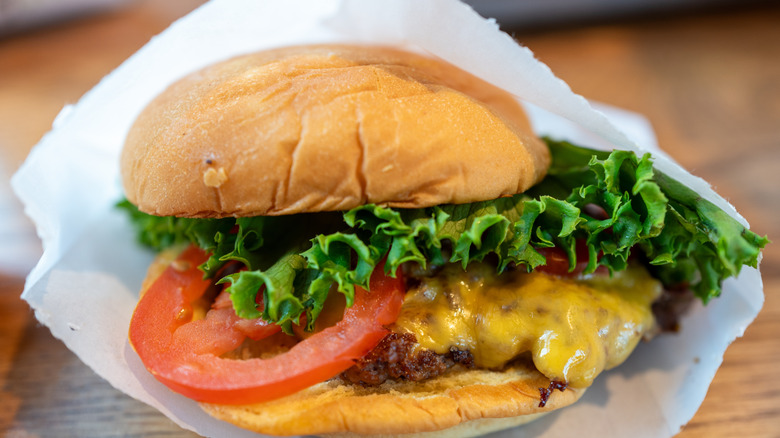 Shake Shack smash burger partially wrapped in white paper