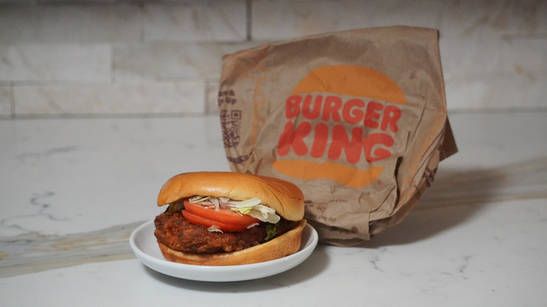 Burger King Spicy Royal Crispy Chicken in front of a Burger King brown paper bag.