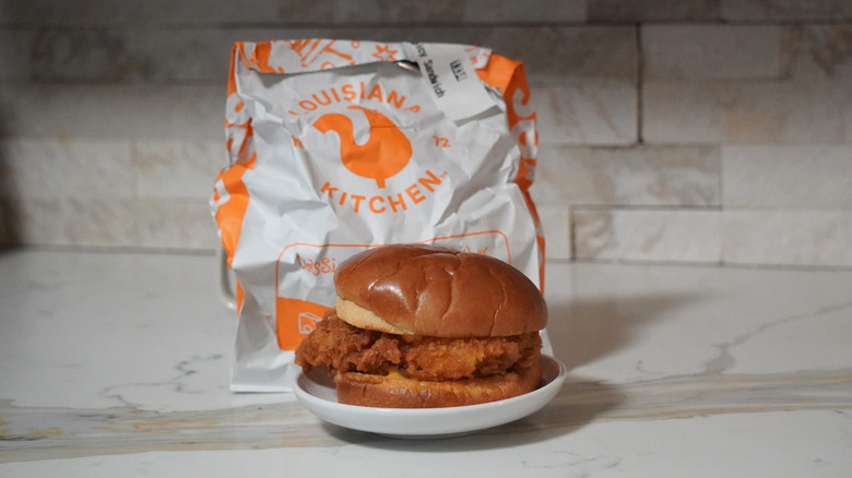 Popeyes Spicy Chicken Sandwich in front of a Popeyes bag.