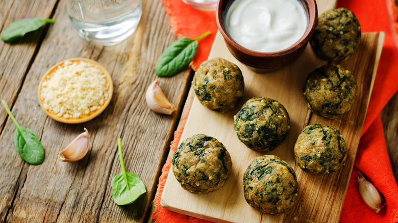 Spinach balls next to a creamy dip