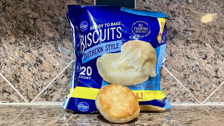 Bag of Kroger Southern Style Frozen Biscuits with cooked one in front