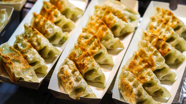 Pan fried mandu in white paper trays