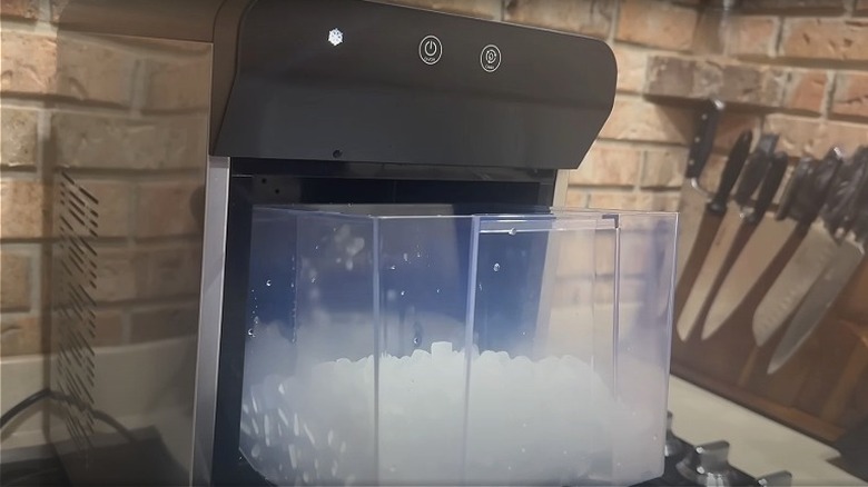 The gevi ice maker sits with its ice compartment open on a countertop