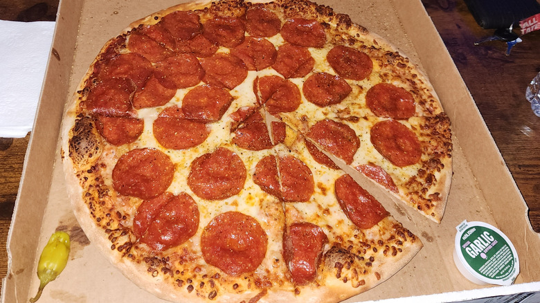 pizza from Papa Johns in a box with a pepper and Special Garlic Sauce dip