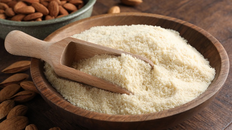 Almond flour in a wooden bowl with a wooden scoop
