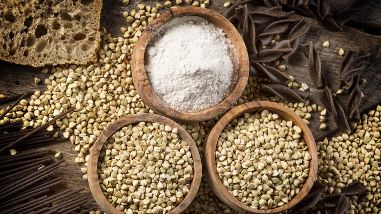 Two bowls of buckwheat kernels and one bowl of buckwheat flour