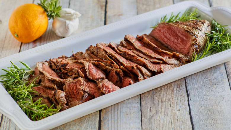 london broil sliced on long serving plate
