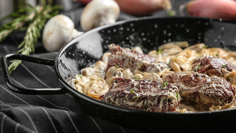 steak diane in pan with mushrooms