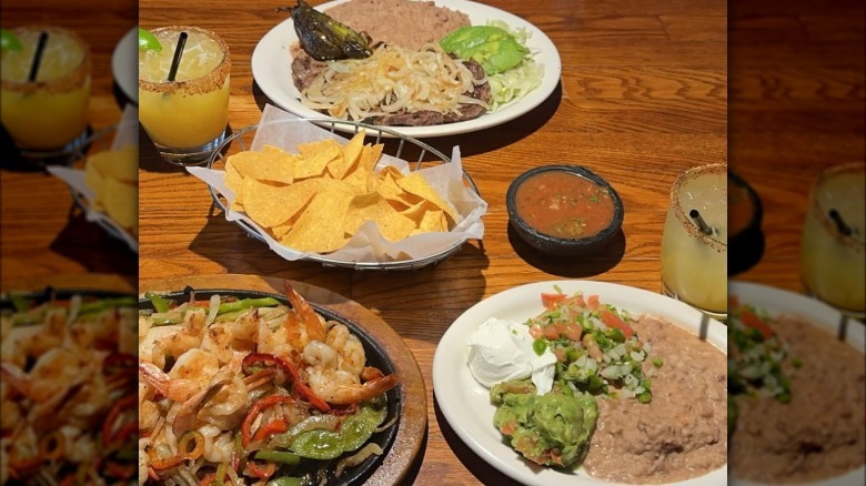 Platters of Mexican food and cocktails on table