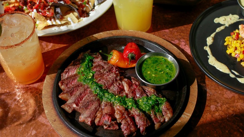 Sliced steak on plate with green sauce