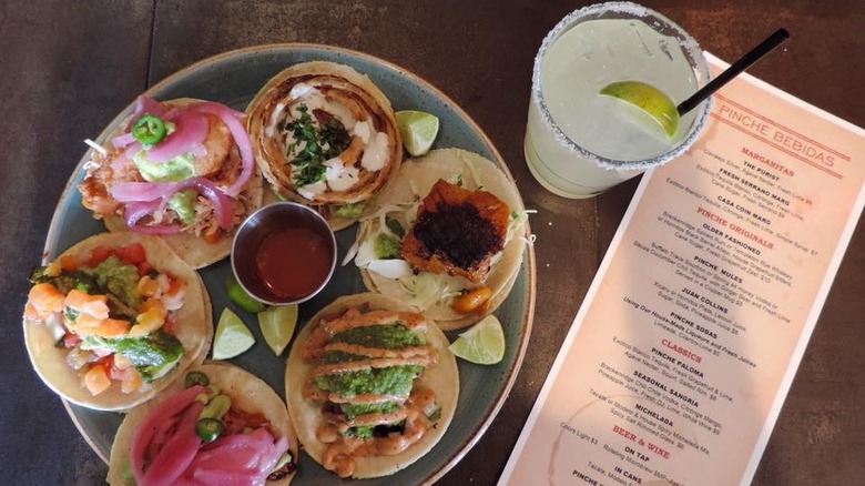 plate of street tacos with margarita and menu