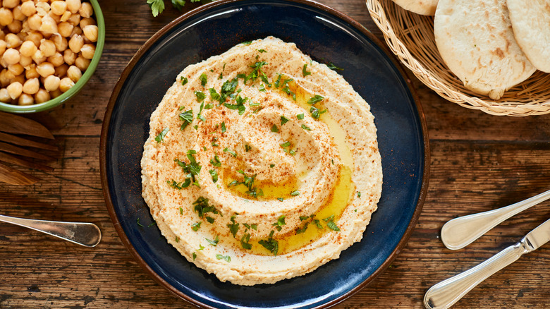 Hummus topped with olive oil in blue bowl