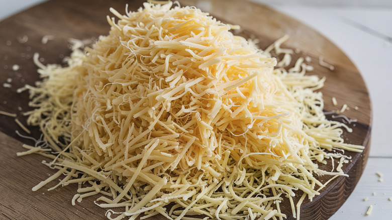 Wooden plate full of shredded cheese