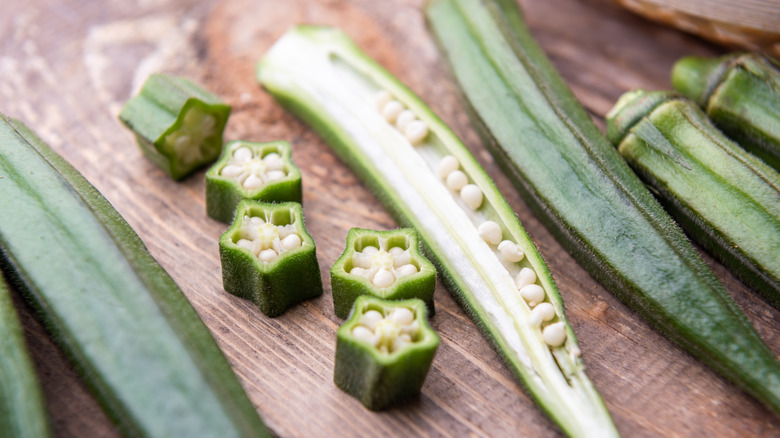 Freshly sliced okra next to a whole stem