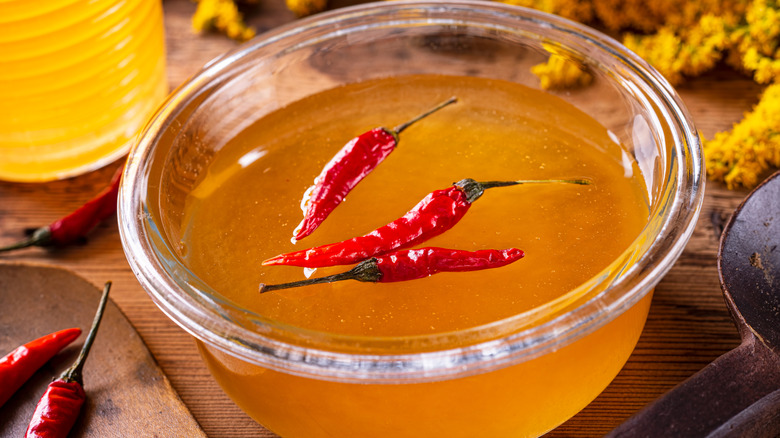 a bowl of honey with chilis inside