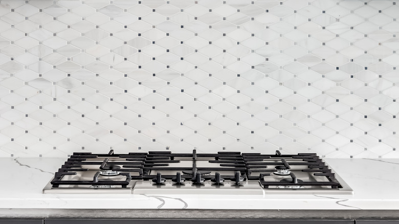 Diamond tile kitchen backsplash behind a gas stove