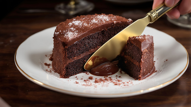 chocolate cake sliced with a golden knife