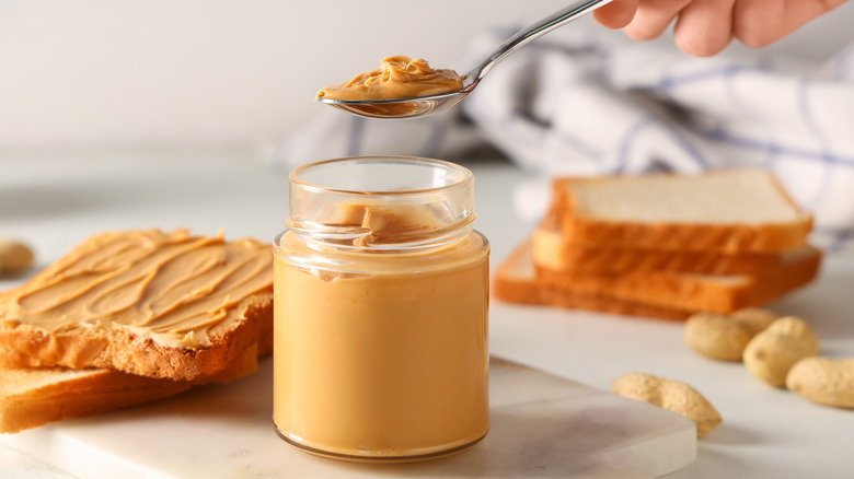 jar of peanut butter with a spoon scooping