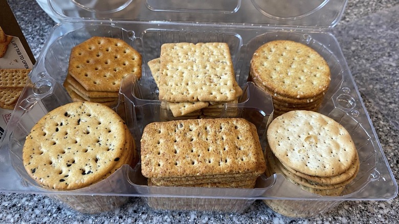 A tray of six types of crackers sits open on a counter