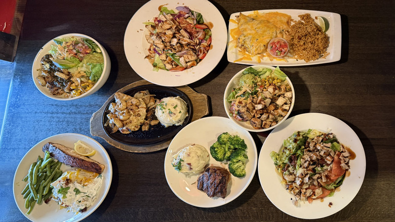Eight plates of food arranged on a tabletop