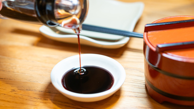 Soy sauce being poured into a small dish