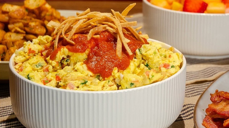 A bowl of veggie scrambled eggs with a salsa and tortilla strip garnish at Mimi's Cafe