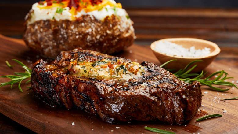 A New York strip steak and baked potato at Firebirds Wood Fired Grill